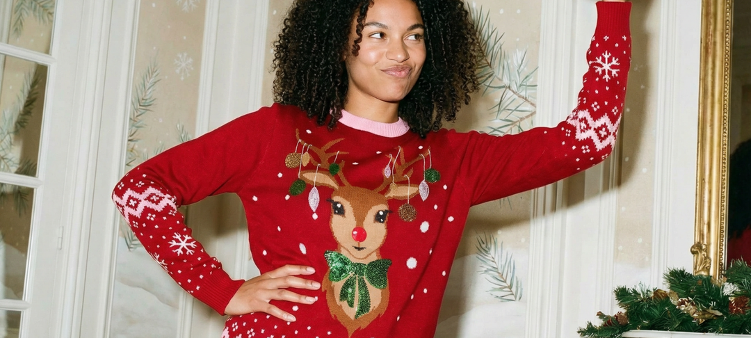 Vrouw poseert vrolijk in een rode foute kersttrui met rendier, perfect voor een gezellige feestelijke date